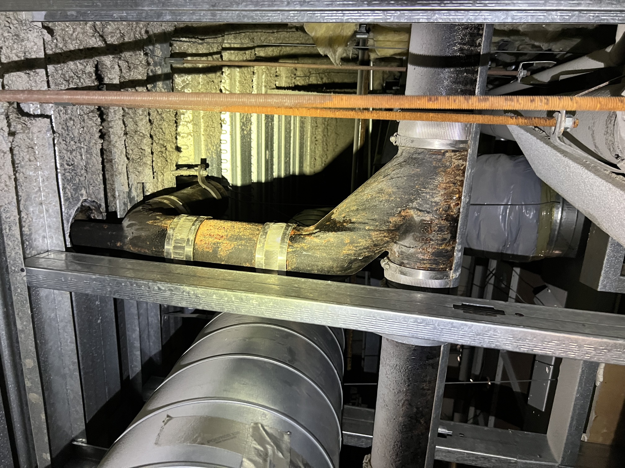 Cast iron riser pipes in multi-family building shaft requiring assessment