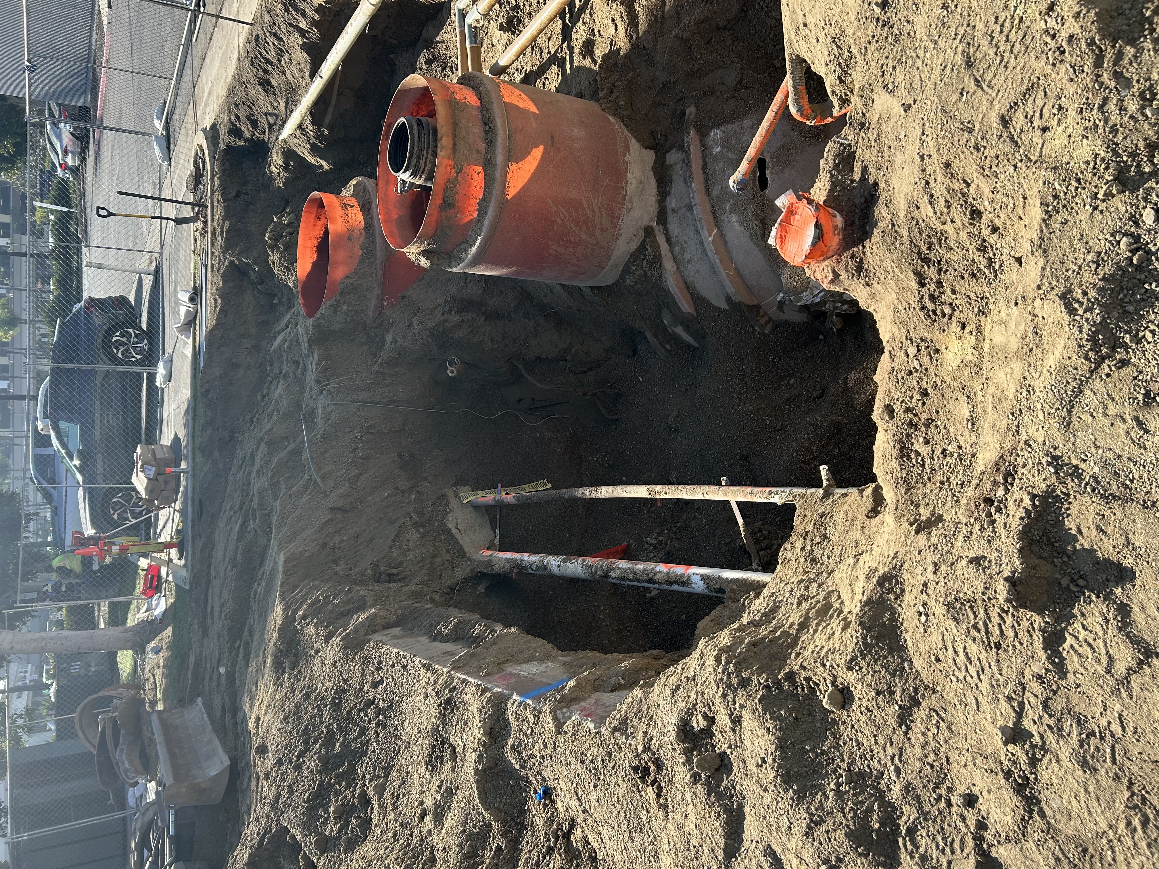 Excavated sewer line with clay pipe connections exposed for replacement