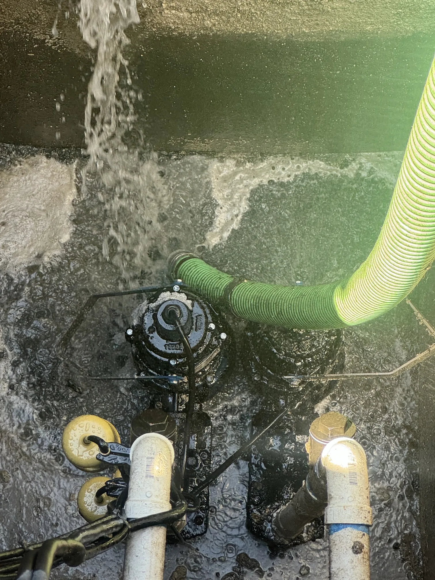 Grease trap pumping service with vacuum hose at commercial kitchen