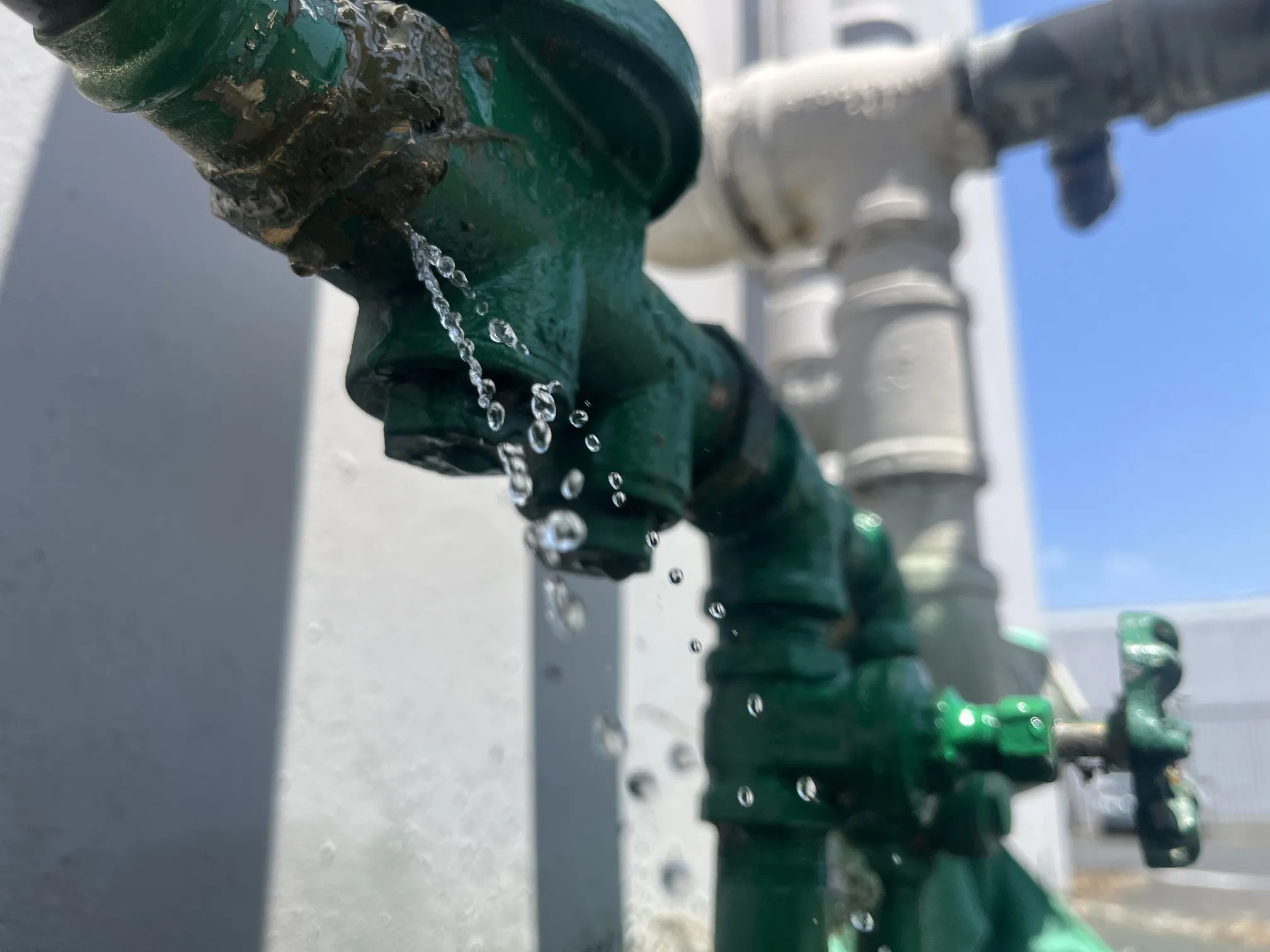 Commercial plumbing valve with water flowing during backflow testing in Orange County